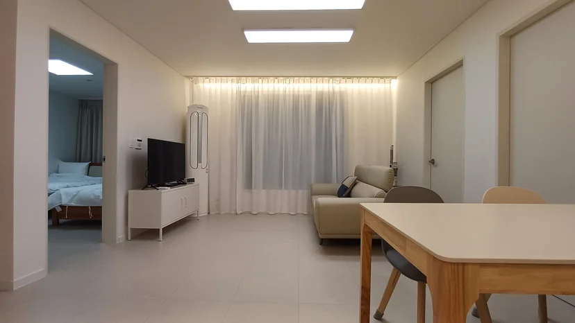 Open living room with a TV, sofa, and a bedroom through the doorway (Listing ID : 38731)
