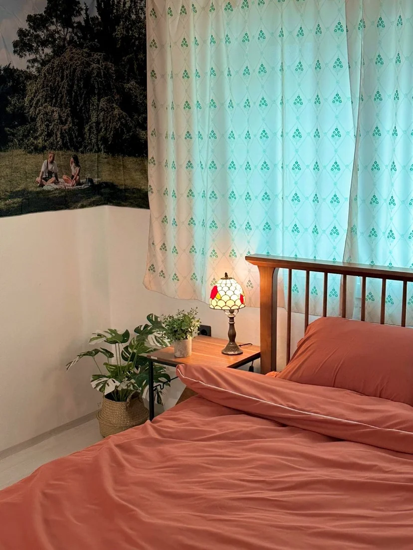 Bedroom with a Tiffany-style lamp and coral bedding (Listing ID : 25342)