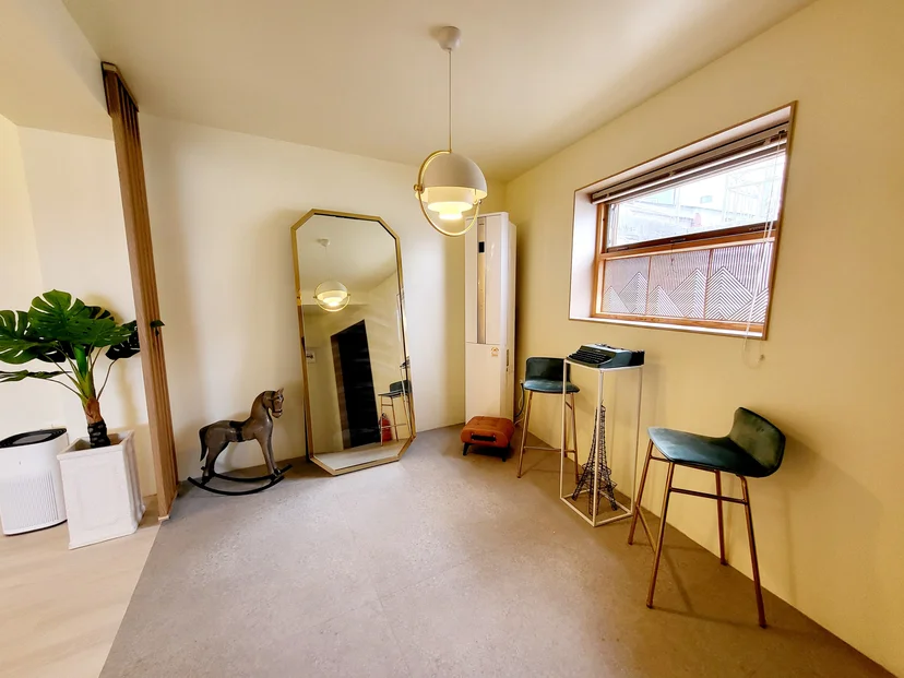 Living area with a floor mirror, green bar stools and a pendant lamp (Listing ID : 37856)