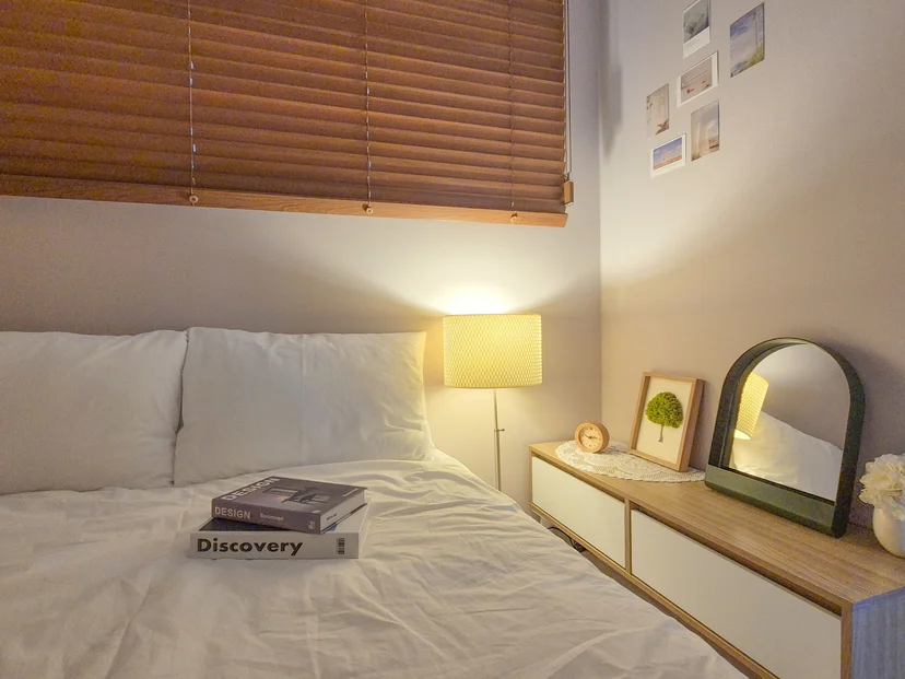 Bedroom with wooden blinds, floor lamp and low dresser with mirror (Listing ID : 36403)