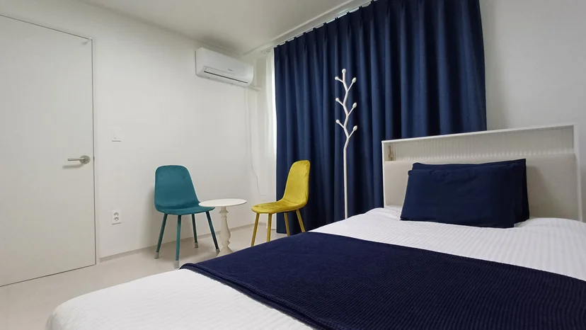 Bedroom with a double bed in navy bedding and accent chairs (Listing ID : 38731)