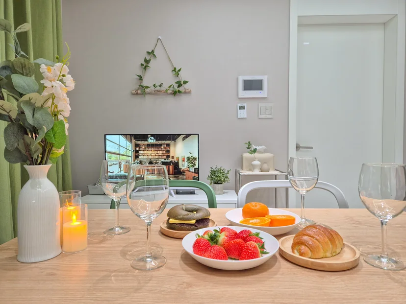 Dining table set with fruit, bread and glasses in the living area (Listing ID : 36403)