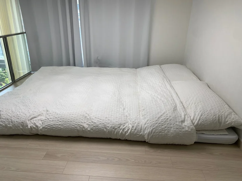 Floor-style bed with white bedding by the window (Listing ID : 42899)