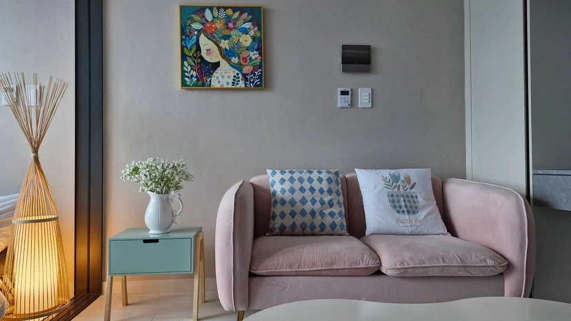 Pink loveseat with cushions, mint side table, floral wall art and a bamboo floor lamp (Listing ID : 22344)