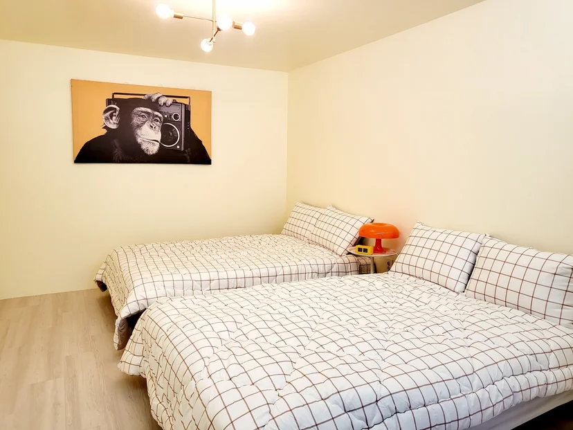 Bedroom with two large beds in checked bedding and an orange lamp (Listing ID : 37856)