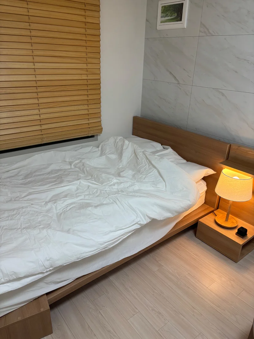 Studio bedroom with a double bed and marble accent wall (Listing ID : 43231)