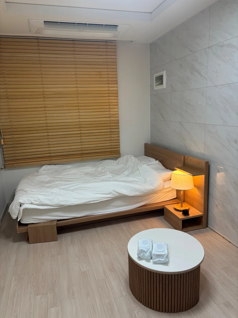Studio sleeping area with a double bed and round table (Listing ID : 43231)