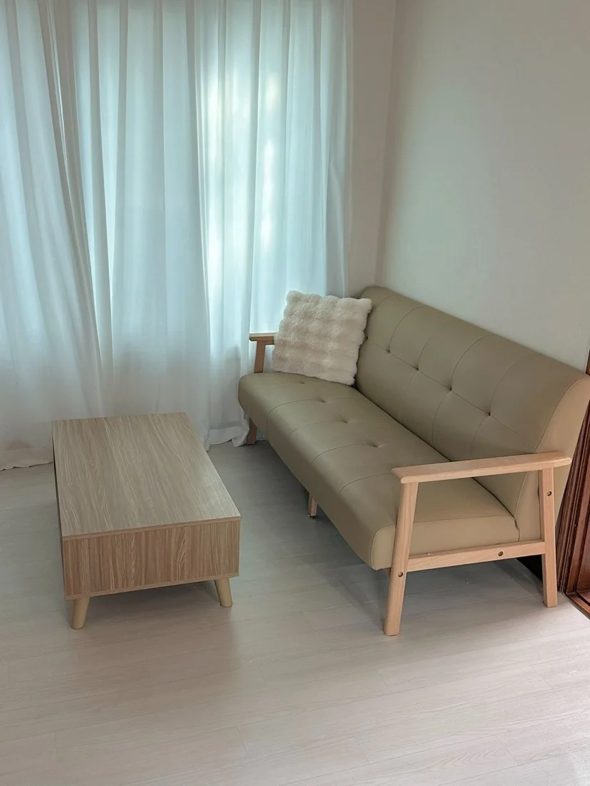 Beige sofa and wooden coffee table by sheer curtains (Listing ID : 25342)