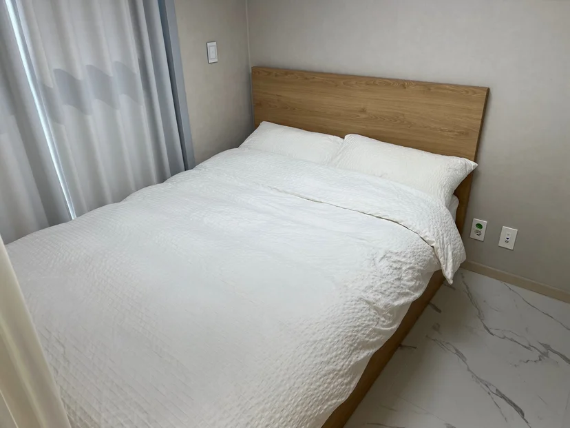 Bright bedroom with a double bed and a wood headboard (Listing ID : 42899)