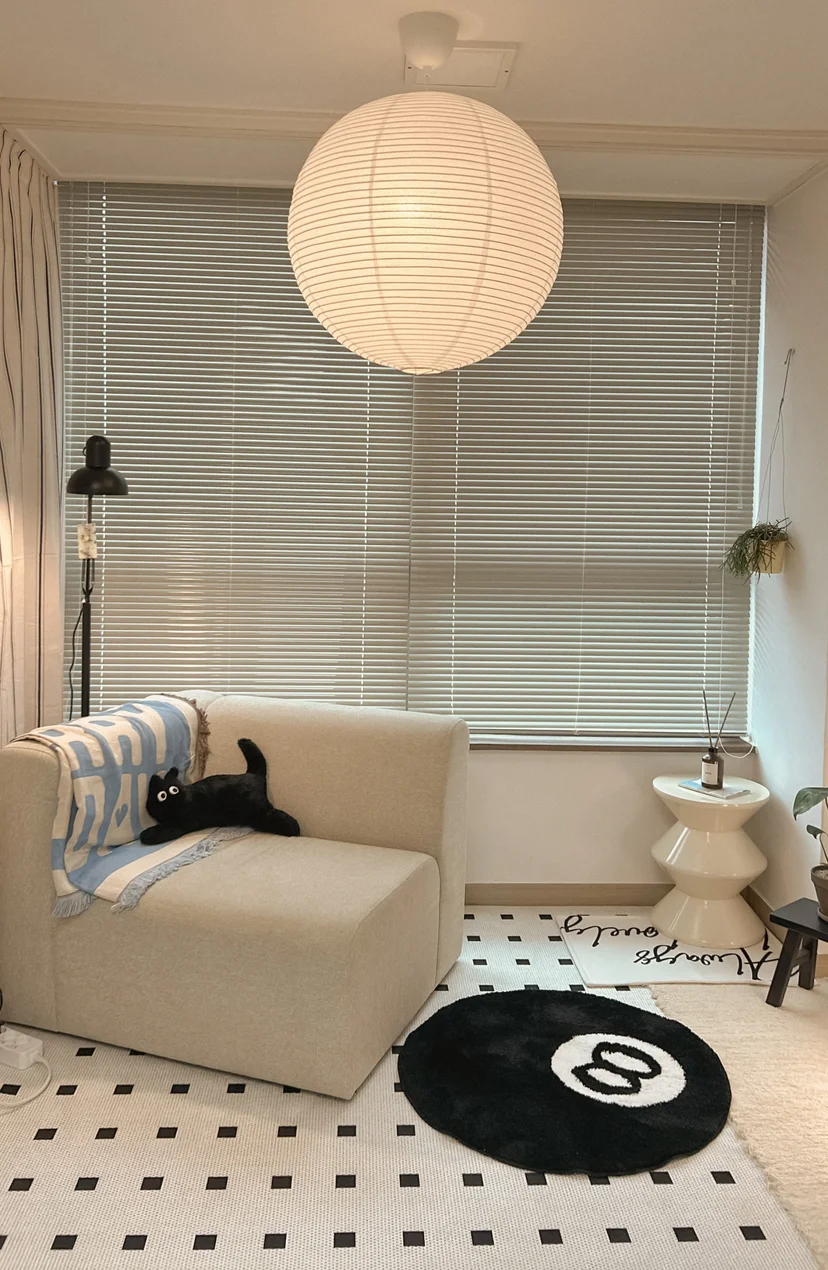 Cozy living corner with beige sofa, paper lantern lamp, and 8-ball rug (Listing ID : 31659)