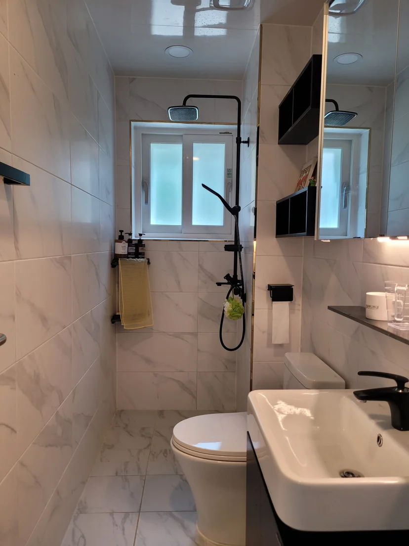 Bathroom with marble-look tiles, black rain shower and white sink (Listing ID : 40873)