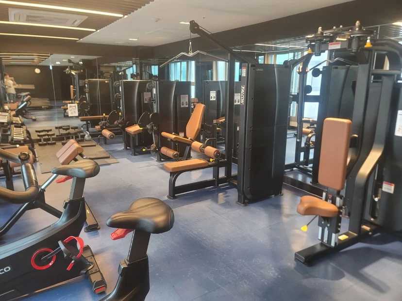 Indoor fitness center with weight machines, cardio bikes, and treadmills inside the residential building (Listing ID : 28279)