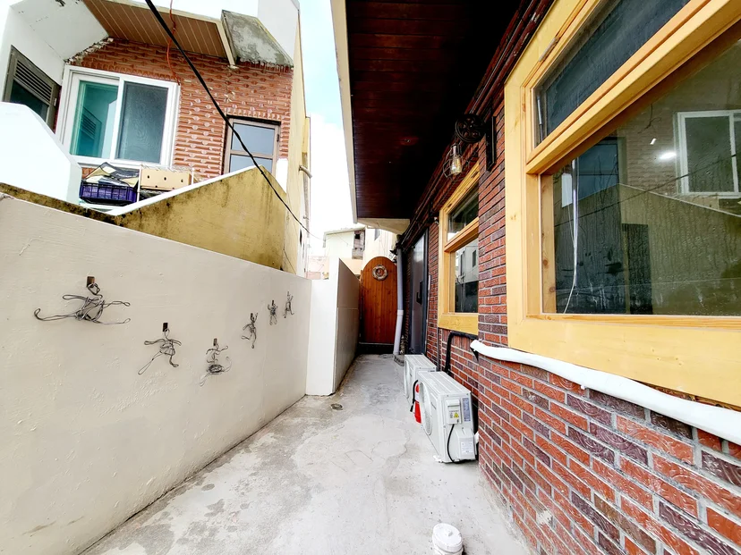 Narrow side path along a brick house with an arched wooden gate (Listing ID : 37856)