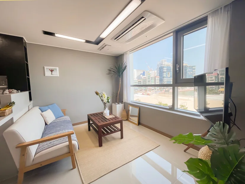 Living room with a sofa and a wide sea-facing window (Listing ID : 30270)
