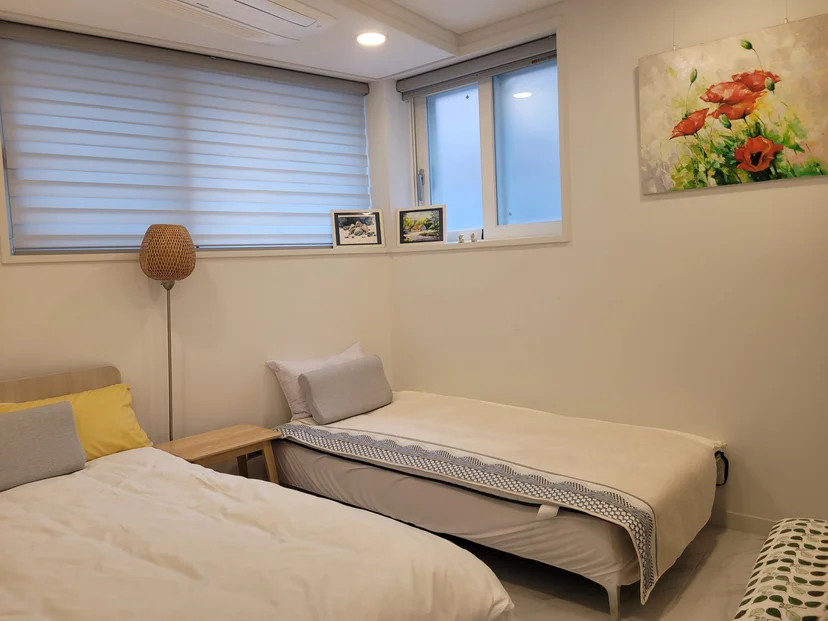 Second bedroom with two single beds and floral wall art (Listing ID : 40873)