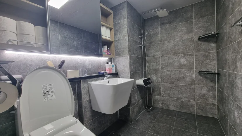 Gray-tiled bathroom with a walk-in shower and wall-mounted sink (Listing ID : 37082)