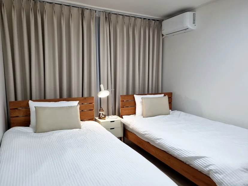 Twin-bed room with wooden headboards and a reading lamp (Listing ID : 38731)