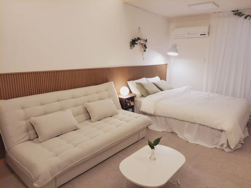 Living area with a beige sofa bed and a wood-slat headboard (집 번호 : 7997)