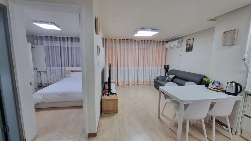 Dining table with four chairs, living area and an open bedroom door (Listing ID : 37082)