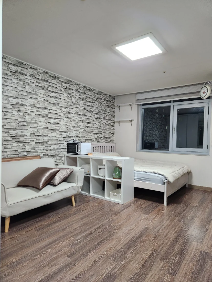 Bedroom with queen bed, sofa, cube shelving, and city-view window (Listing ID : 31503)