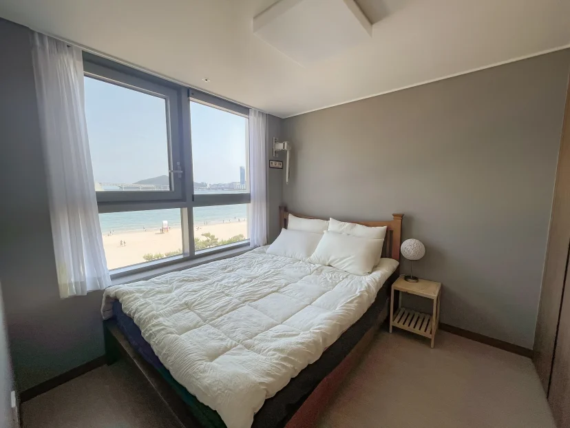 Bedroom with a double bed and a bright ocean-view window (Listing ID : 30270)
