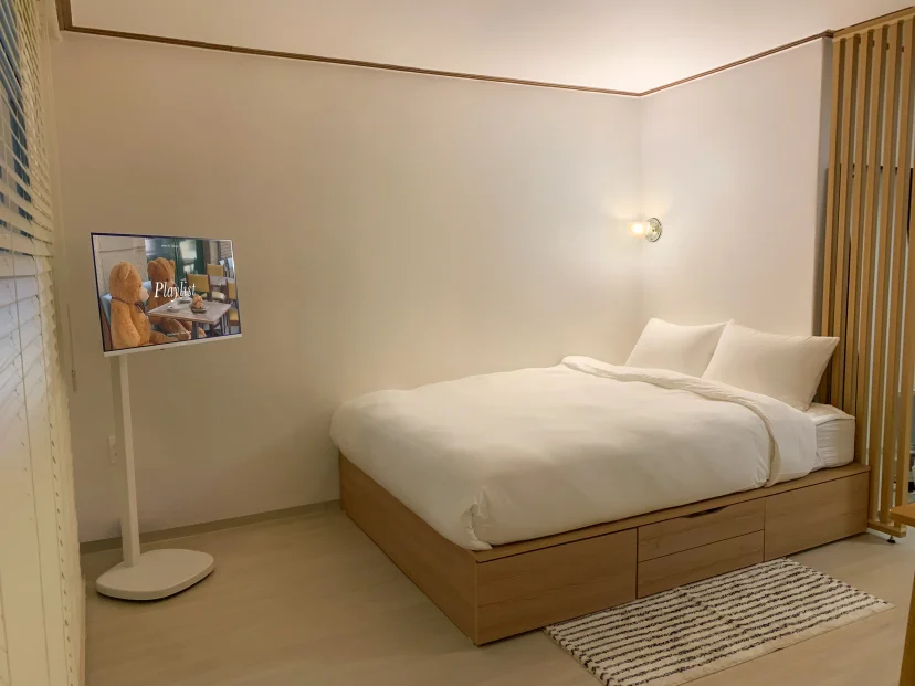Sleeping area with a standing TV and wall sconce (Listing ID : 46336)