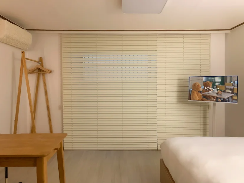 Bedroom window with blinds, wooden clothes rack and wall TV (Listing ID : 46336)