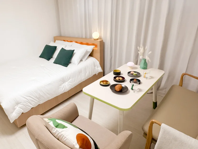 Bedroom with a warm-lit wood headboard and green cushions (Listing ID : 47877)