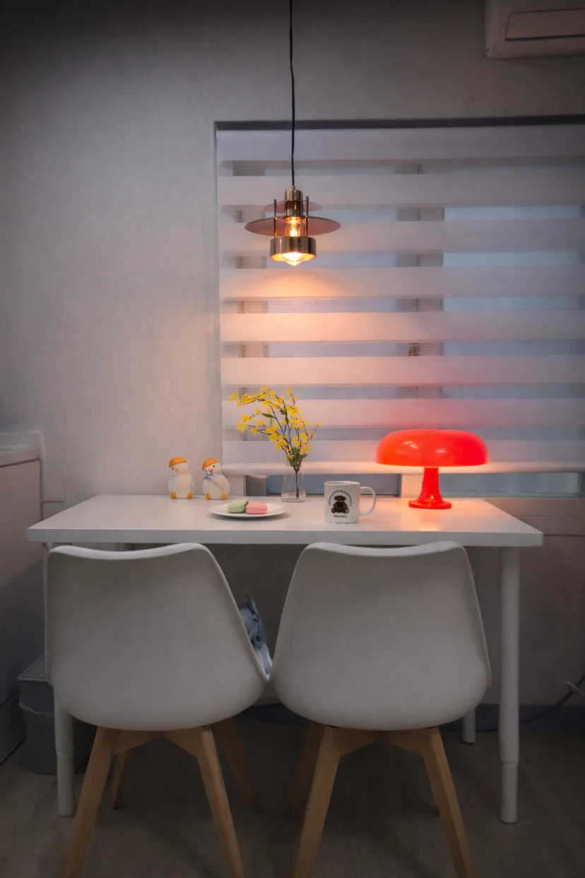 Dining nook with two chairs and a red mushroom lamp inside the studio (Listing ID : 43555)