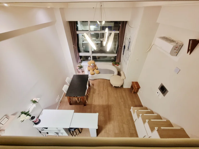 Loft studio seen from the mezzanine, dining table and sofa below (Listing ID : 44519)