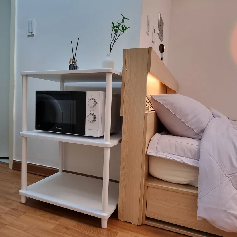 White shelving with microwave beside a wood-headboard bed (Listing ID : 15851)