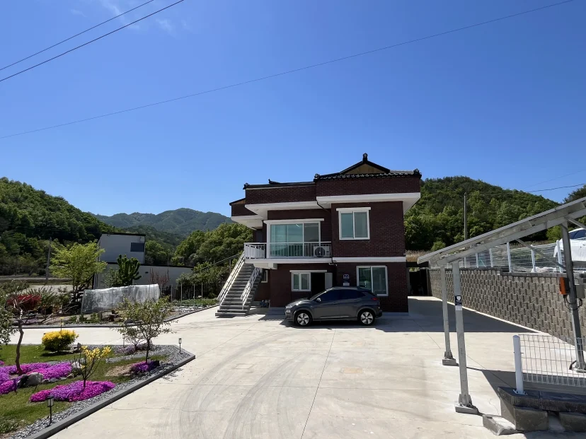 Brick house with an exterior staircase and a paved yard against a mountain backdrop (Listing ID : 51184)