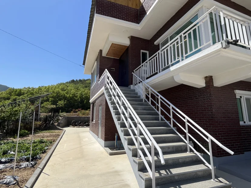 Exterior staircase to the second-floor entrance beside the vegetable patch (Listing ID : 51184)