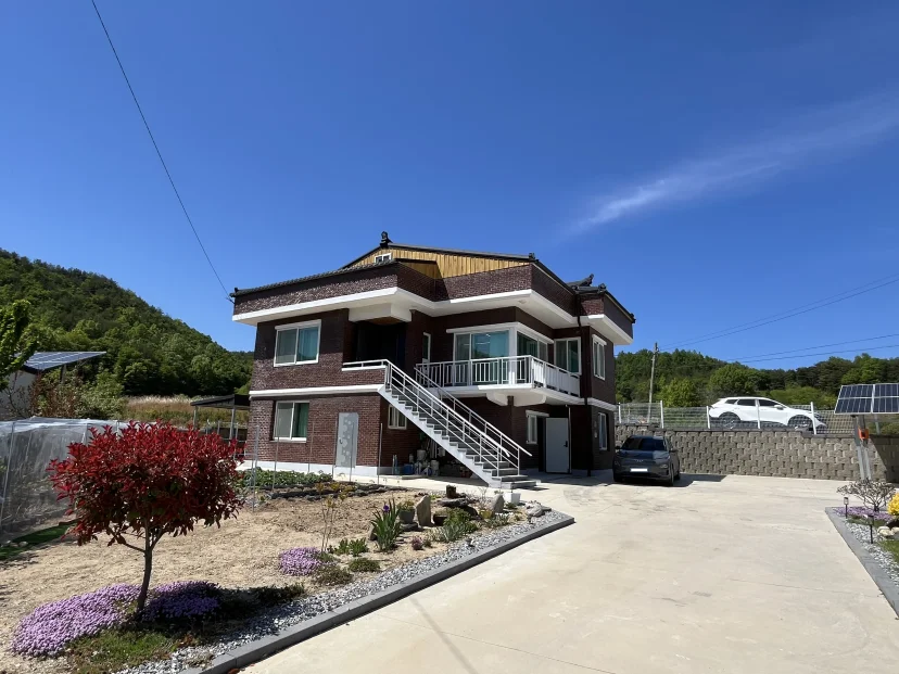 Front of a two-storey brick house with a driveway and white stairs (Listing ID : 51184)