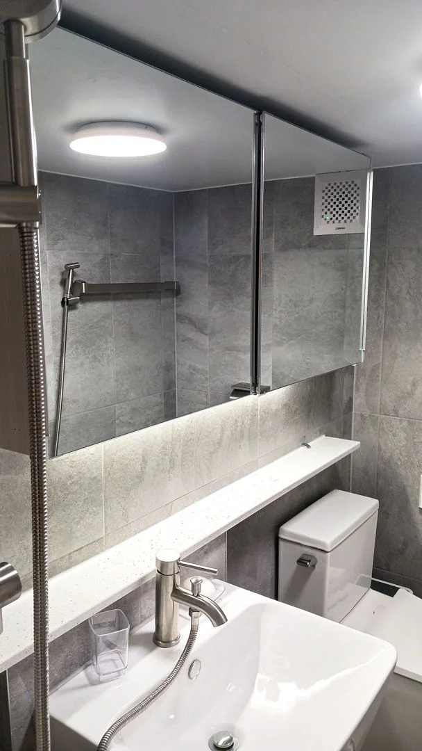 Modern grey-tiled bathroom with a wide vanity and large mirror (Listing ID : 29514)