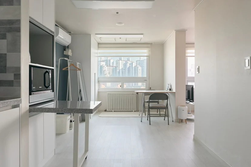 Bright studio entrance looking toward a window desk and city view (Listing ID : 32541)