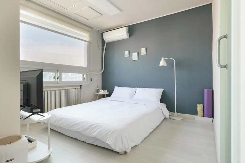 Bedroom with white double bed, floor lamp and wide window (Listing ID : 32541)