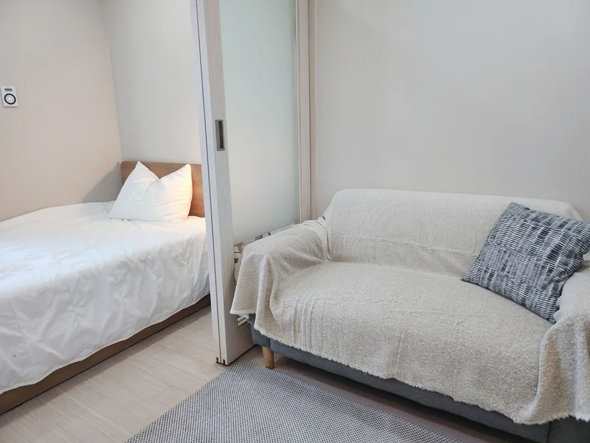 Small sofa with a throw beside the sliding door to the sleeping area (Listing ID : 27331)