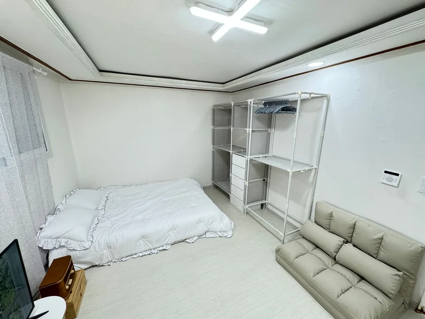 Room with a double bed, an open wardrobe rack, and a sofa (Listing ID : 26009)