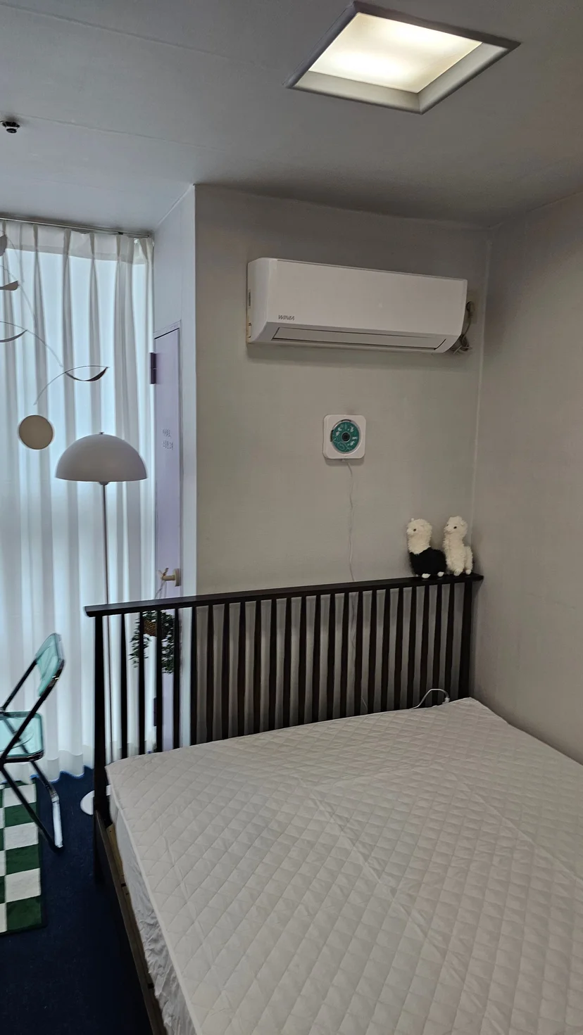 Queen bed under a wall-mounted air conditioner (Listing ID : 28024)