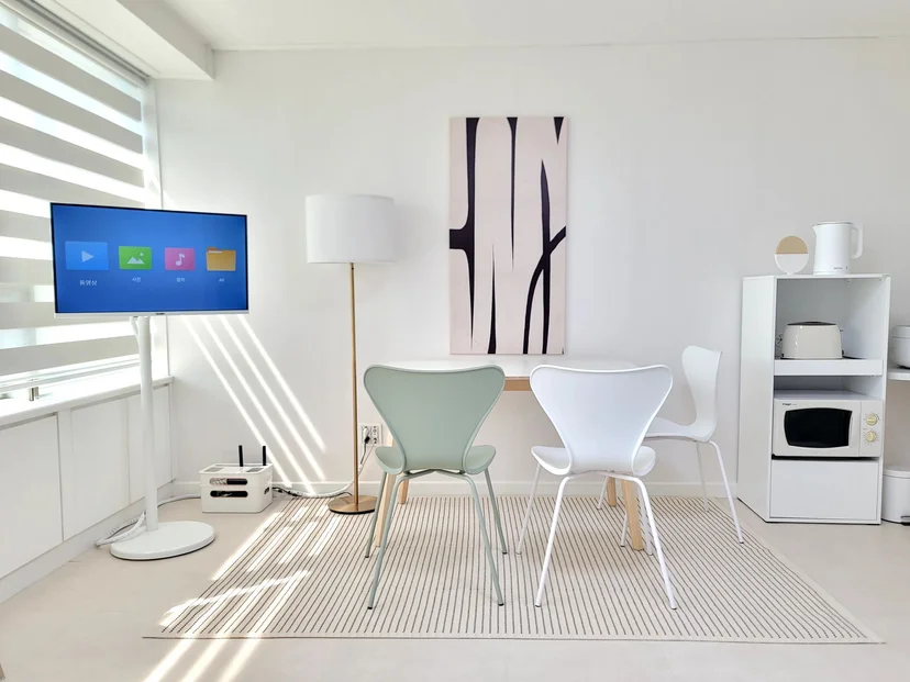White-toned studio with dining table, chairs and a TV (Listing ID : 29409)