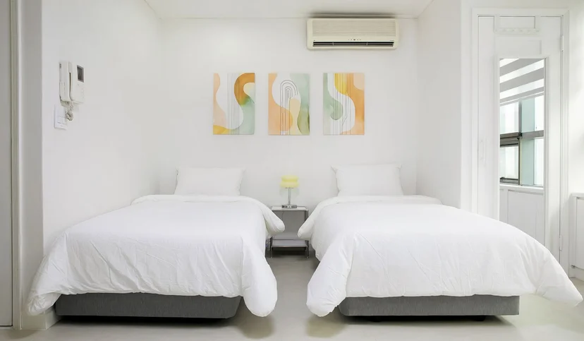Two single beds with a bedside table and wall air conditioner (Listing ID : 29409)