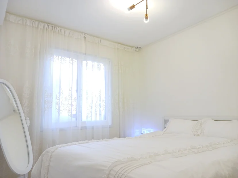 Bright bedroom with sheer lace curtains and a soft white bed (Listing ID : 29514)