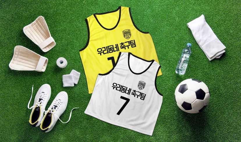 마플 메쉬 팀 조끼 팀명·번호를 인쇄한 옐로우·화이트 조끼 2종을 축구 용품과 함께 잔디 위에 배치한 사양 이미지