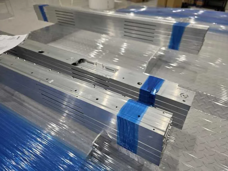 CNC machined aluminum battery component with precision slots and protective packaging