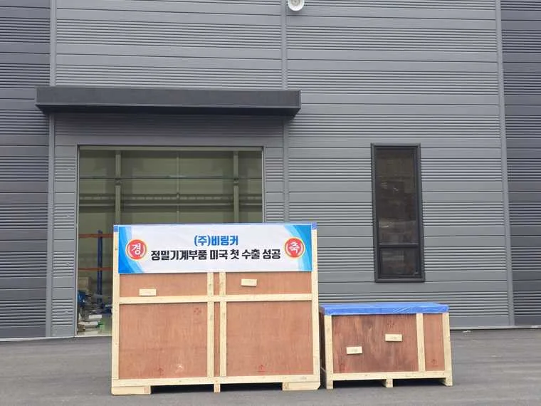 Belinker export crates with celebration banner marking first successful precision parts export to the United States