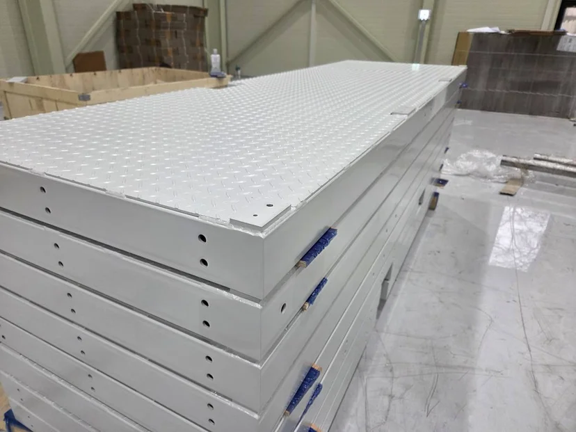 Precision CNC machined checker plate steel platforms stacked in Korean factory