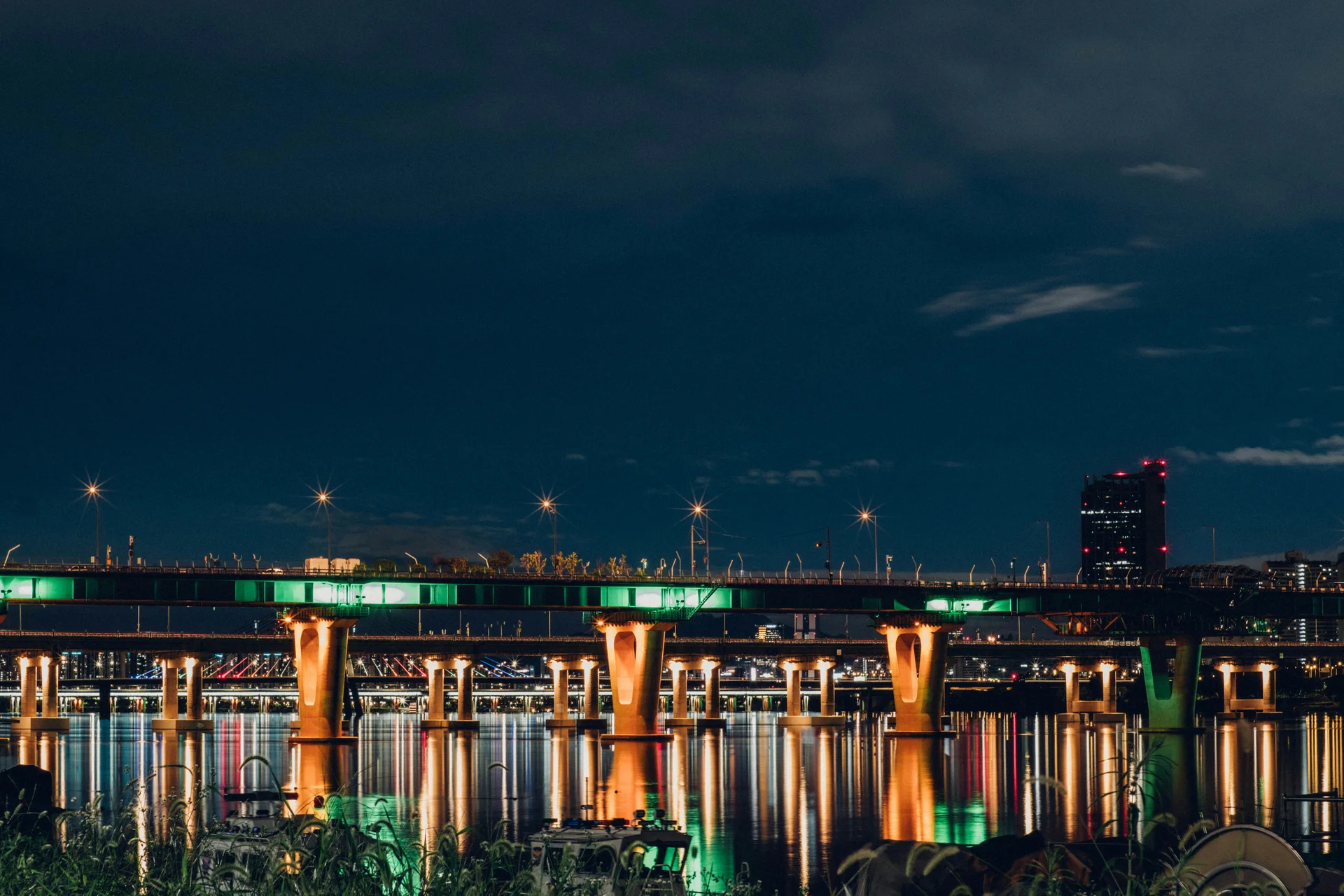 Illuminated bridge over water at night in Busan