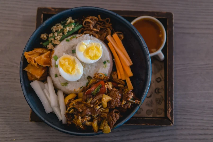 Korean bibimbap in a hot stone bowl with colorful vegetables arranged on rice