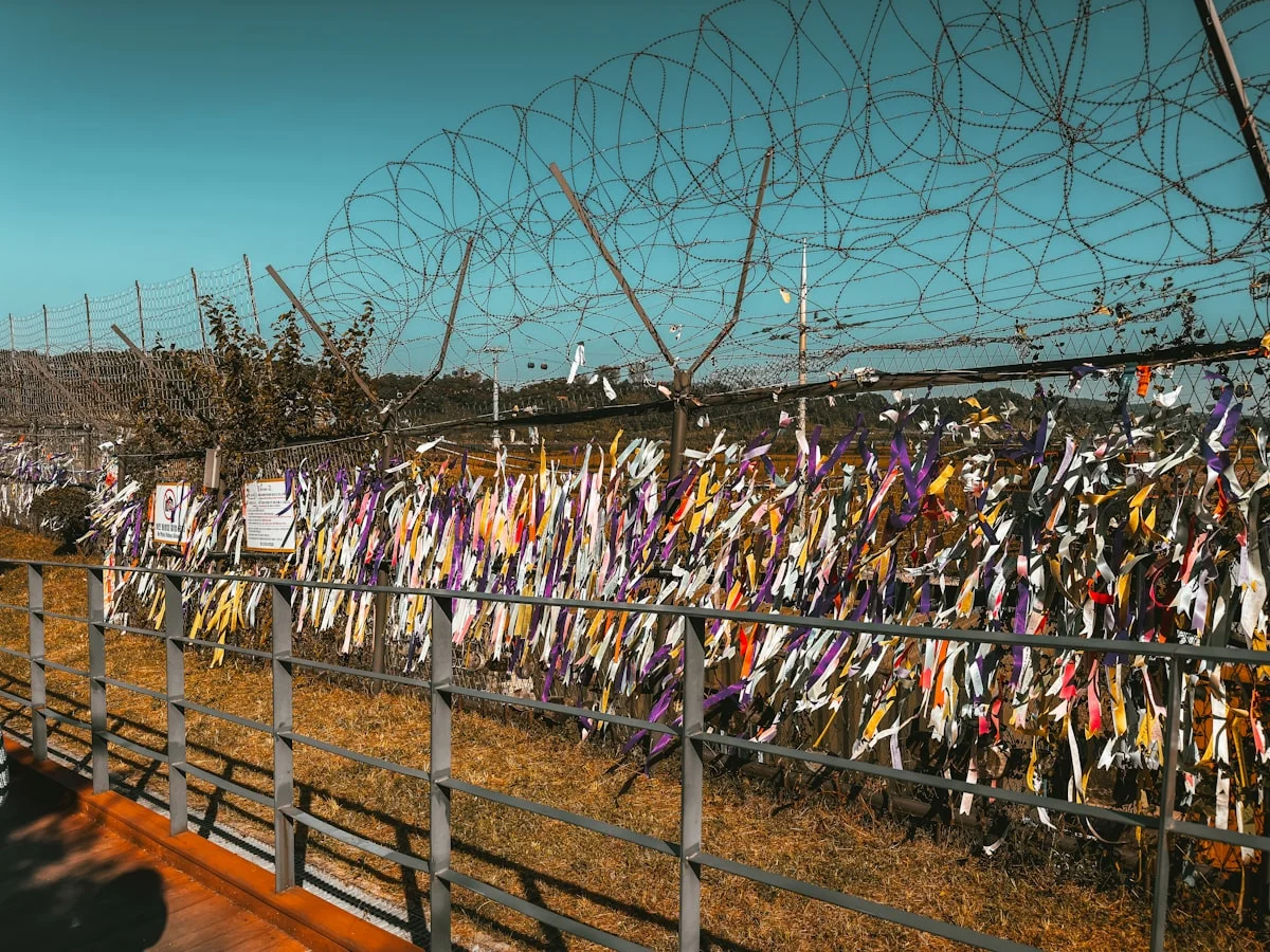 Colorful ribbons tied to a fence at Imjingak Park near the DMZ, carrying messages of hope for Korean reunification